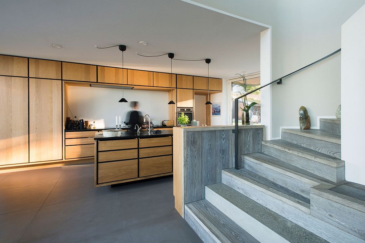 Beautiful contemporary kitchen with wooden cabinets, island and dark lines that anchor it visually