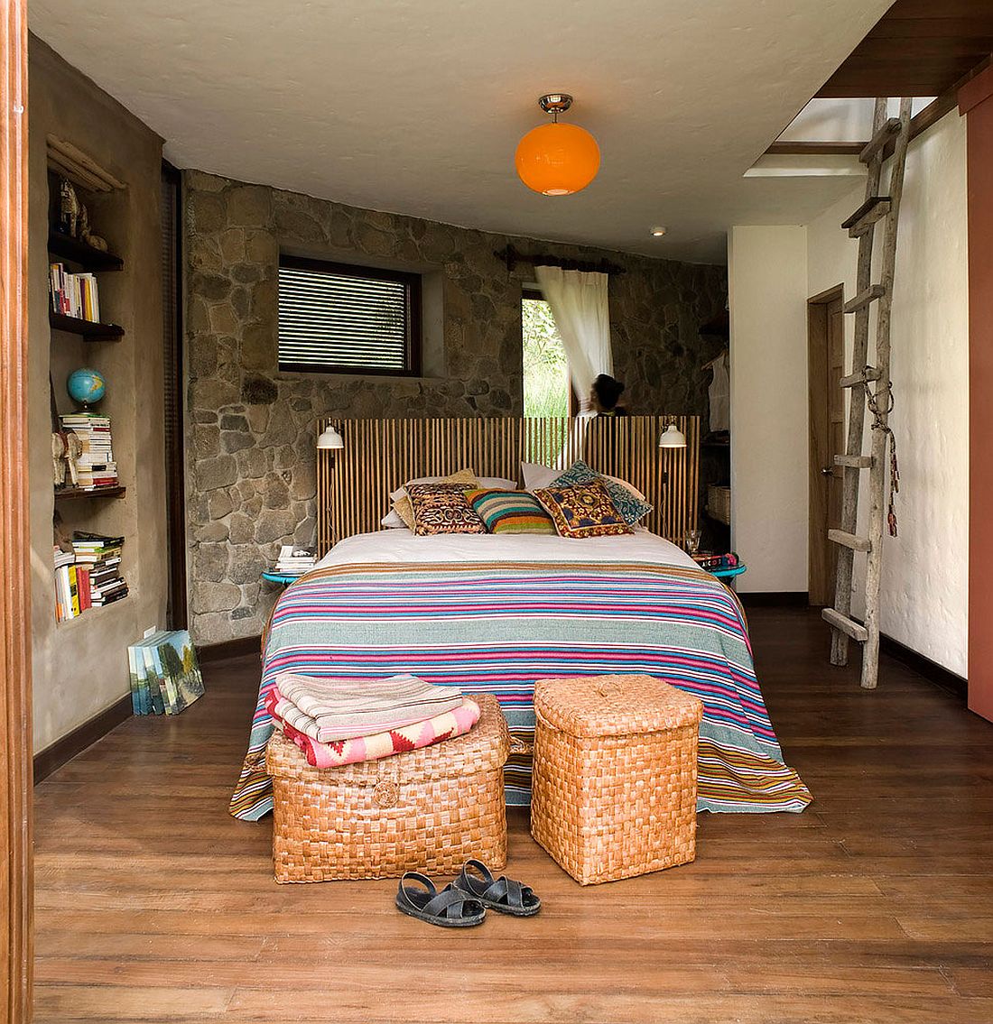 Bedroom with stone accent wall and colorful bedding