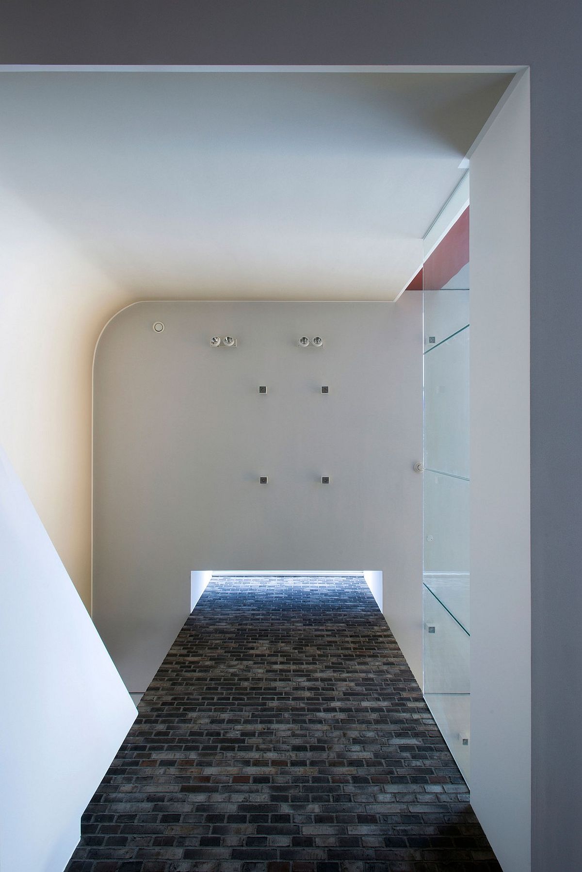 Brick fireplace wall that extends all the way up towards the skylight on the top level