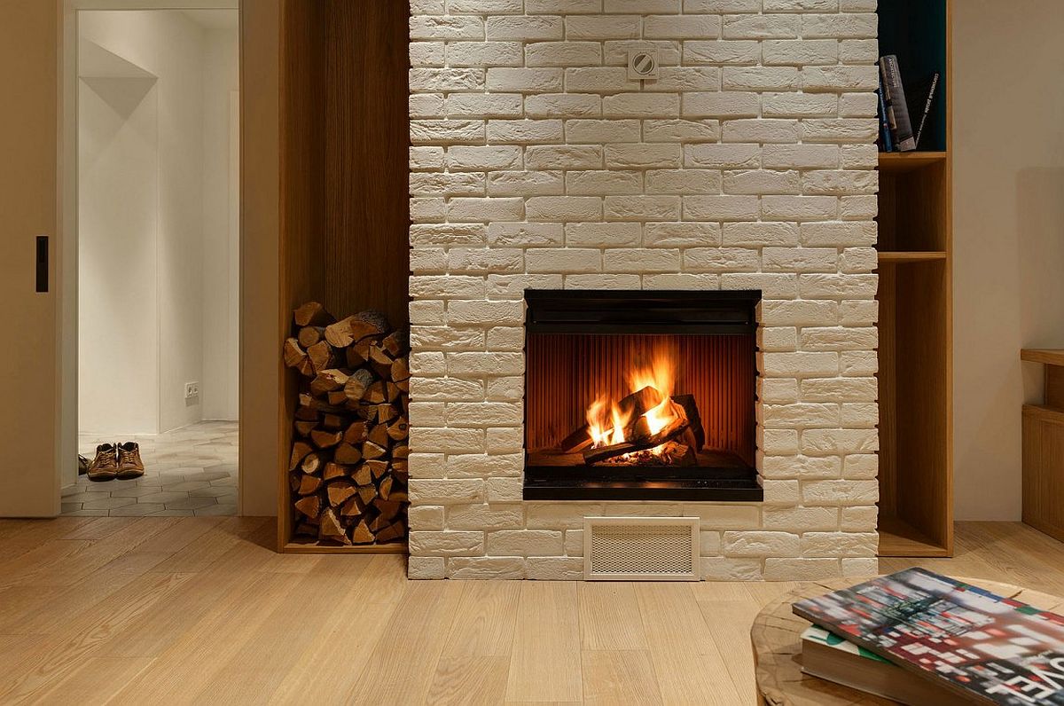 Brick fireplace with stacked wood next to it