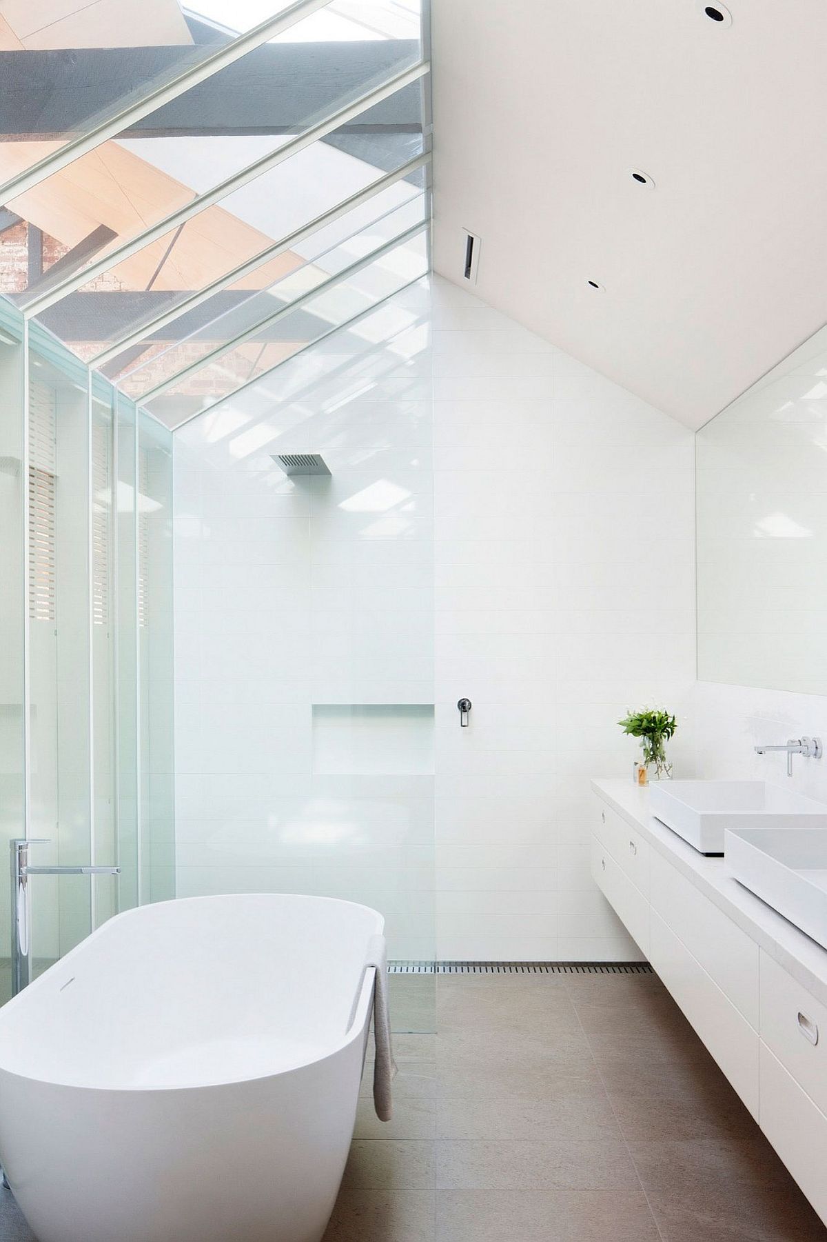 Contemporary bathroom in white with skylight and standalone bathtub