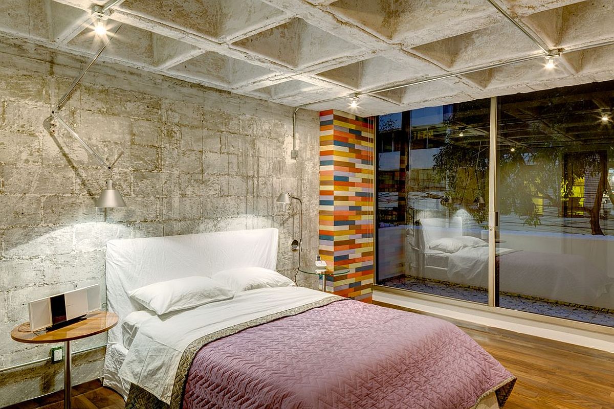 Contemporary bedroom with custom wooden flooring and concrete walls