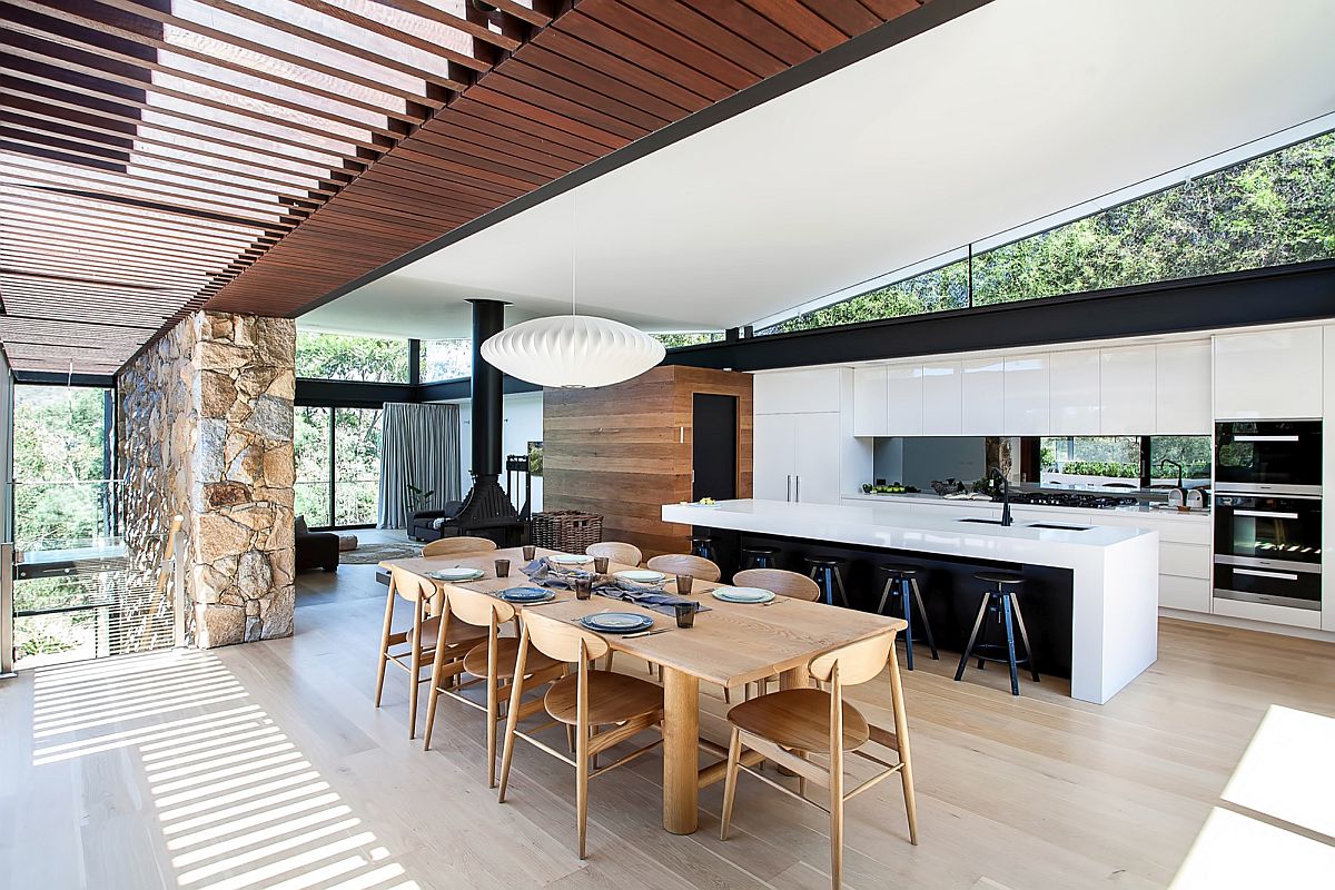 Dining room adds warmth of wood to the stone and glass home