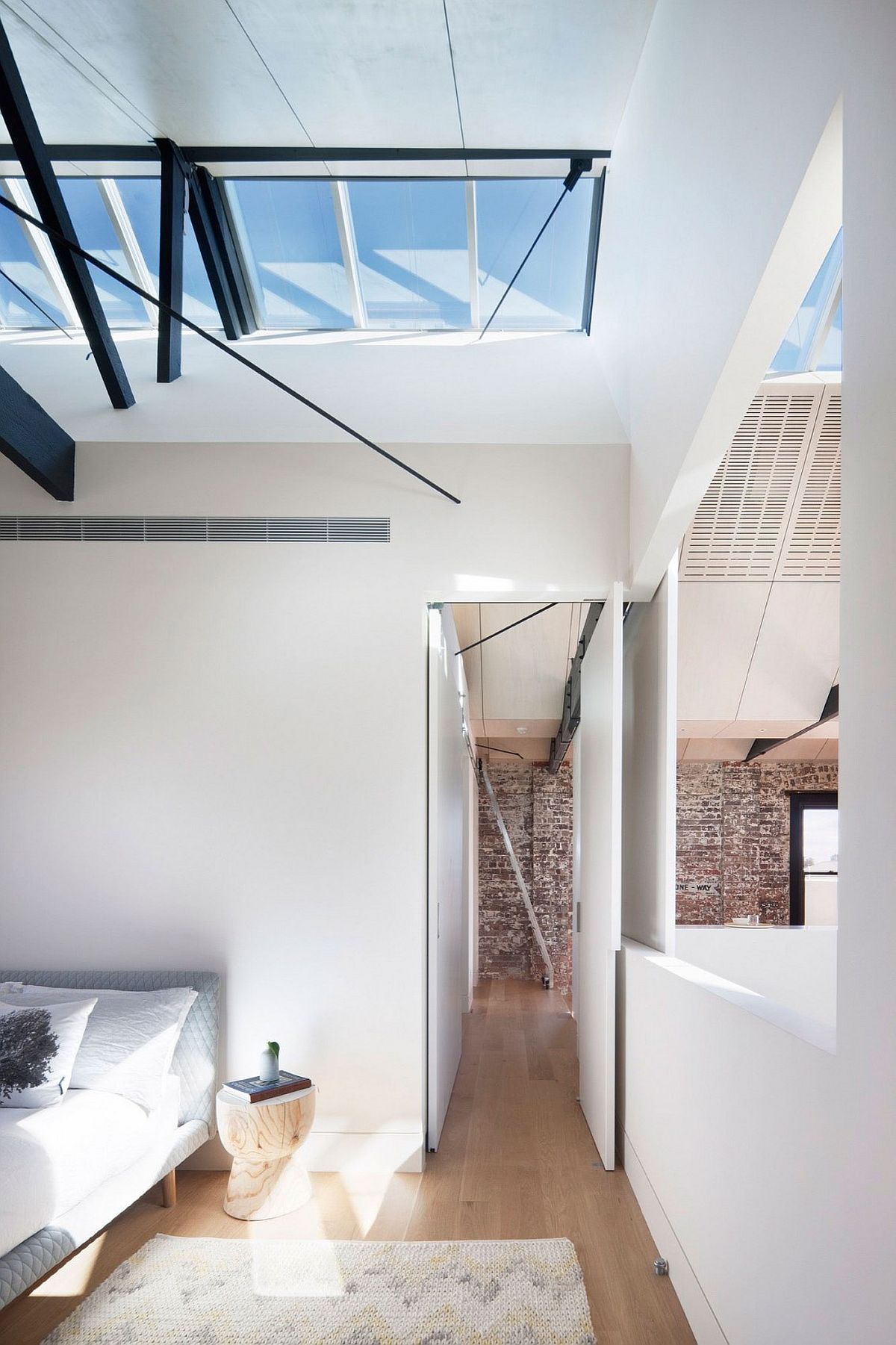 Exposed brick walls stand in contrast to the white, modern surfaces inside the house