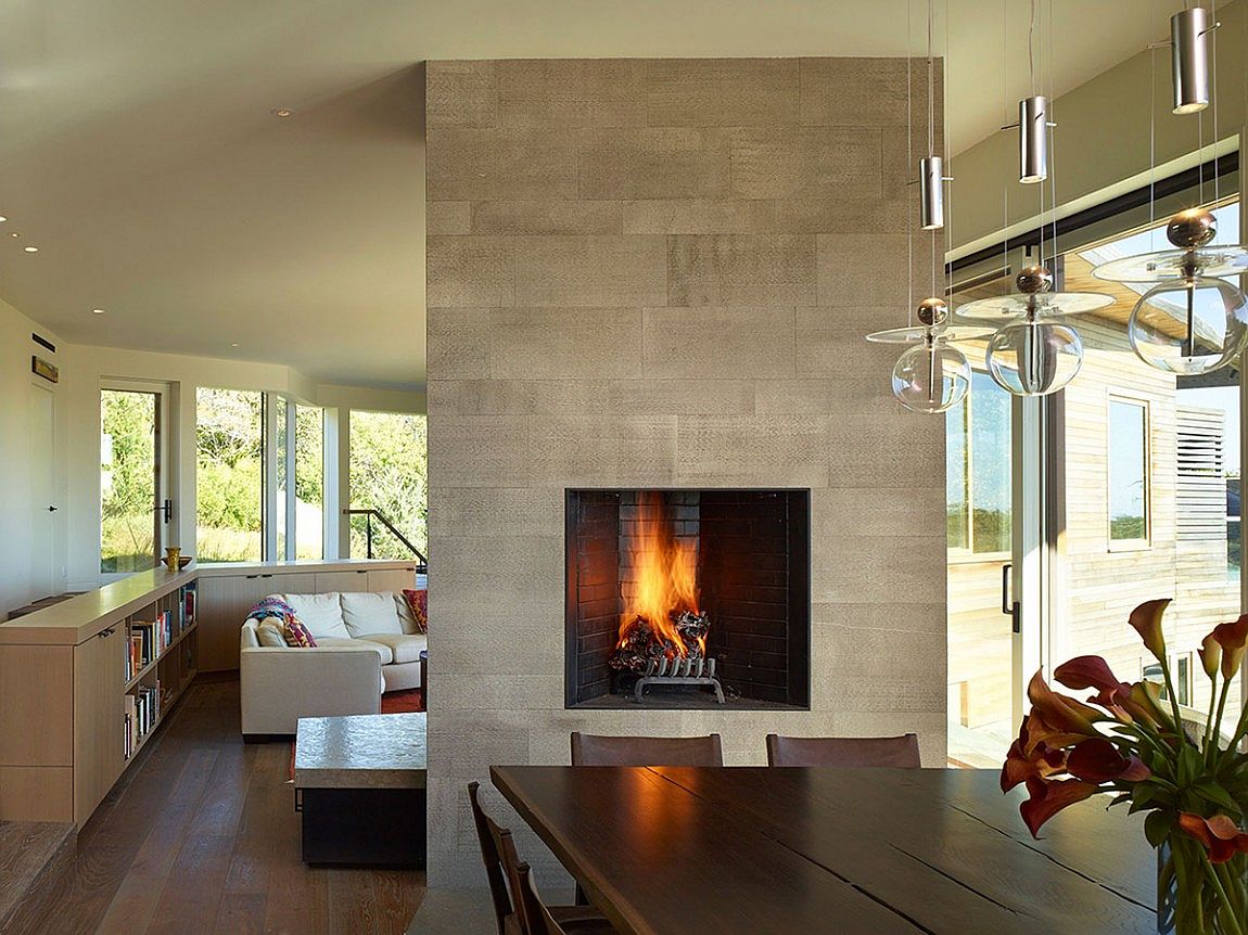 Fireplace delineates the dining space from the living room