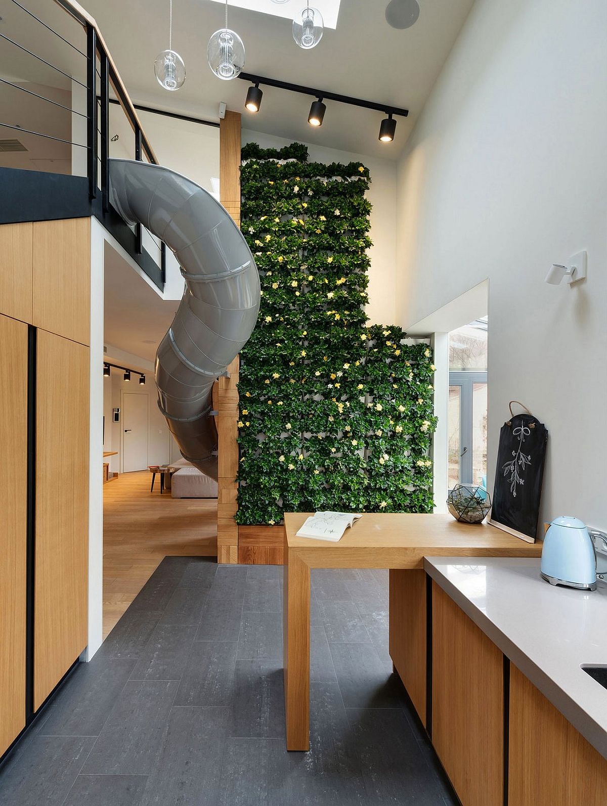 Green wall and slide shape a stunning and fun apartment in Ukraine