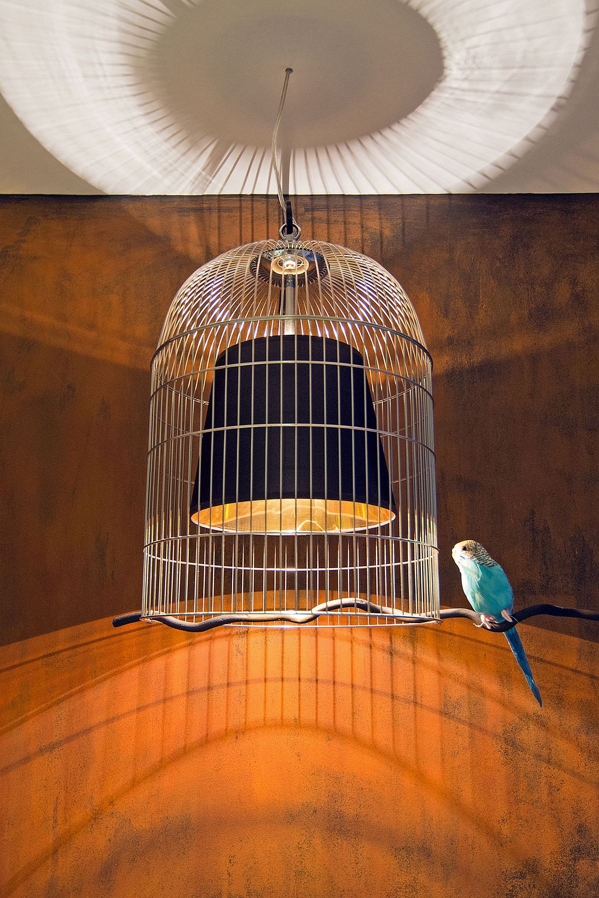 Ingenious and playful pendant light design with a birdcage around it