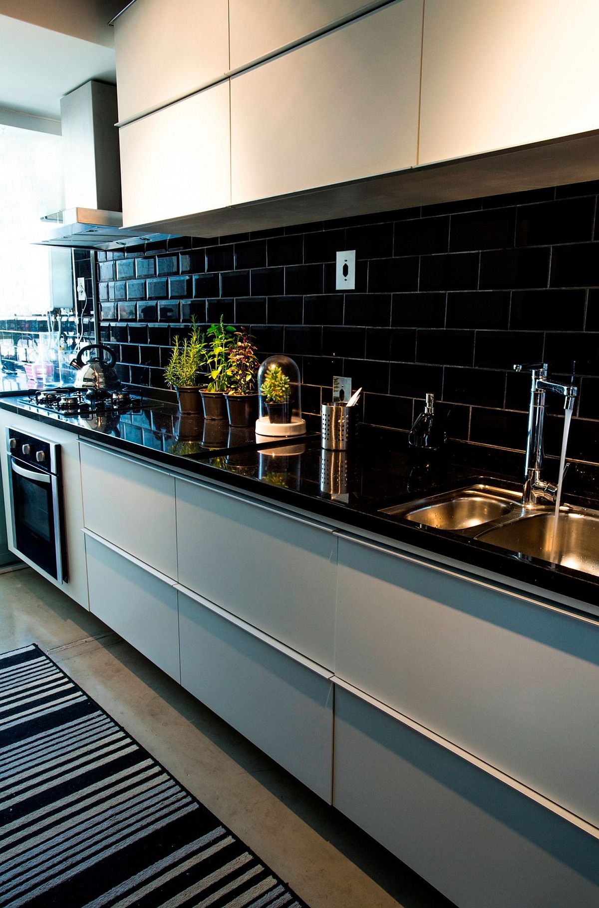 Kitchen with black countertop and black tiled backsplash