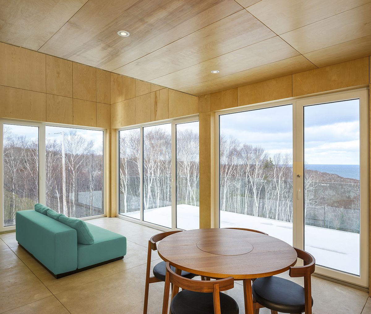 Living room on the third floor of the cabin with view of the coastline in the distance