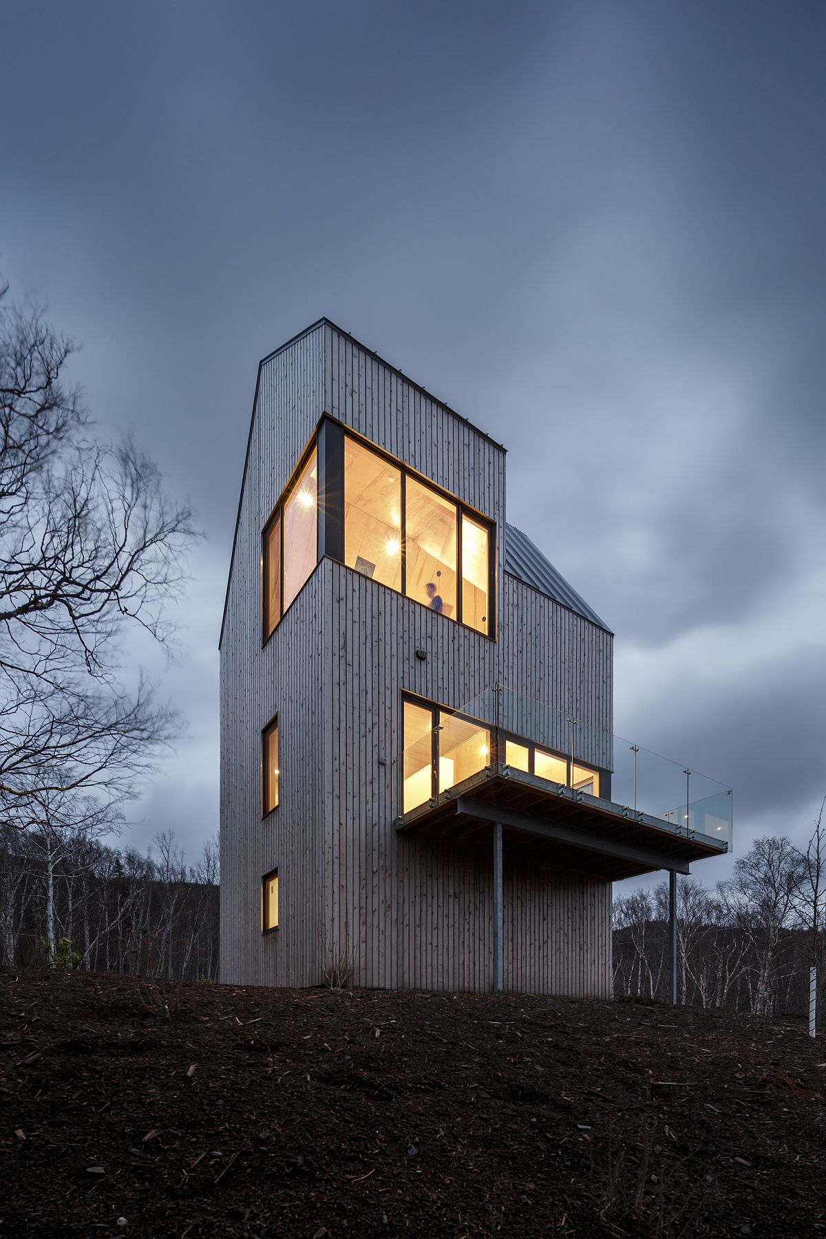 Local wood board cladding covers the exterior of the unique cabin