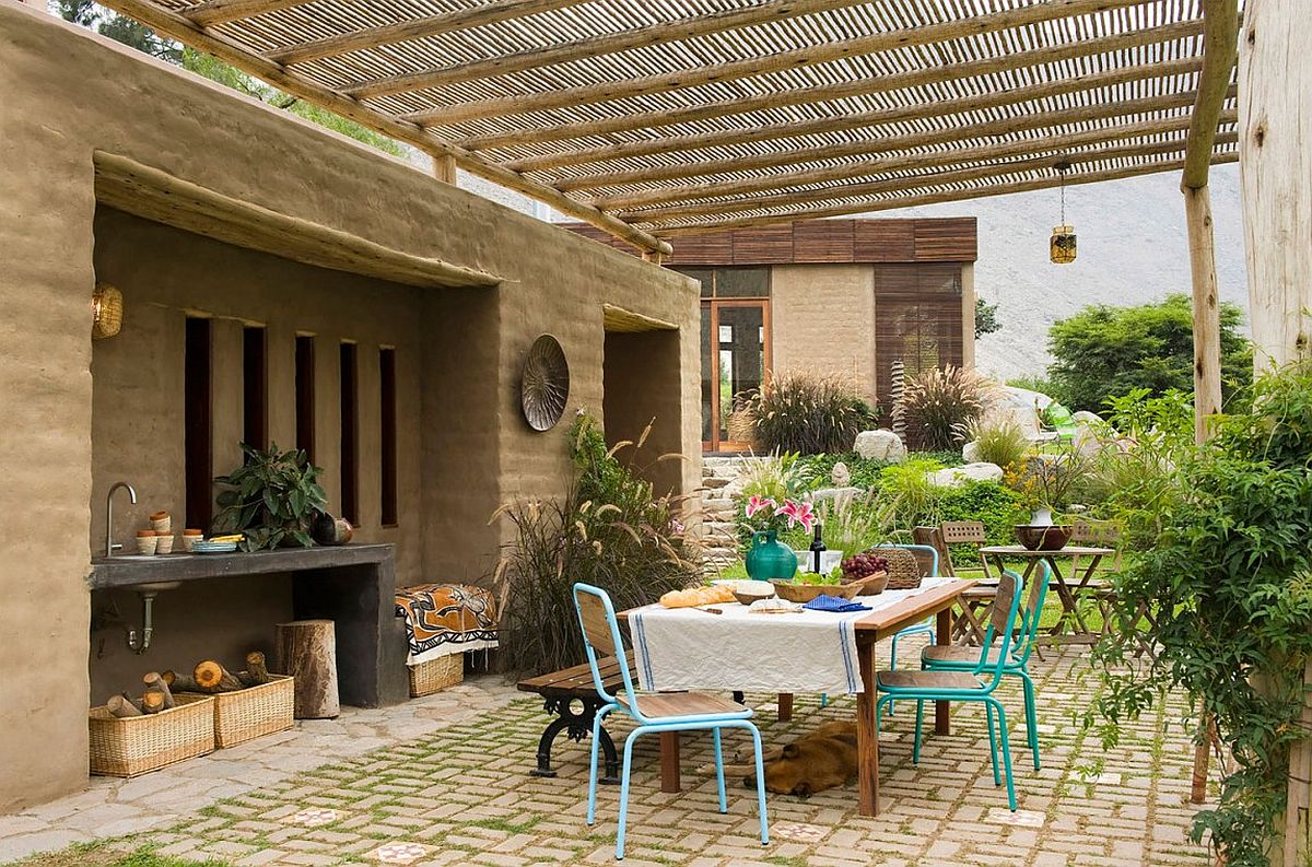 Outdoor dining space surrounded by a beautiful wall of greenery and fetauring an outdoor worktop