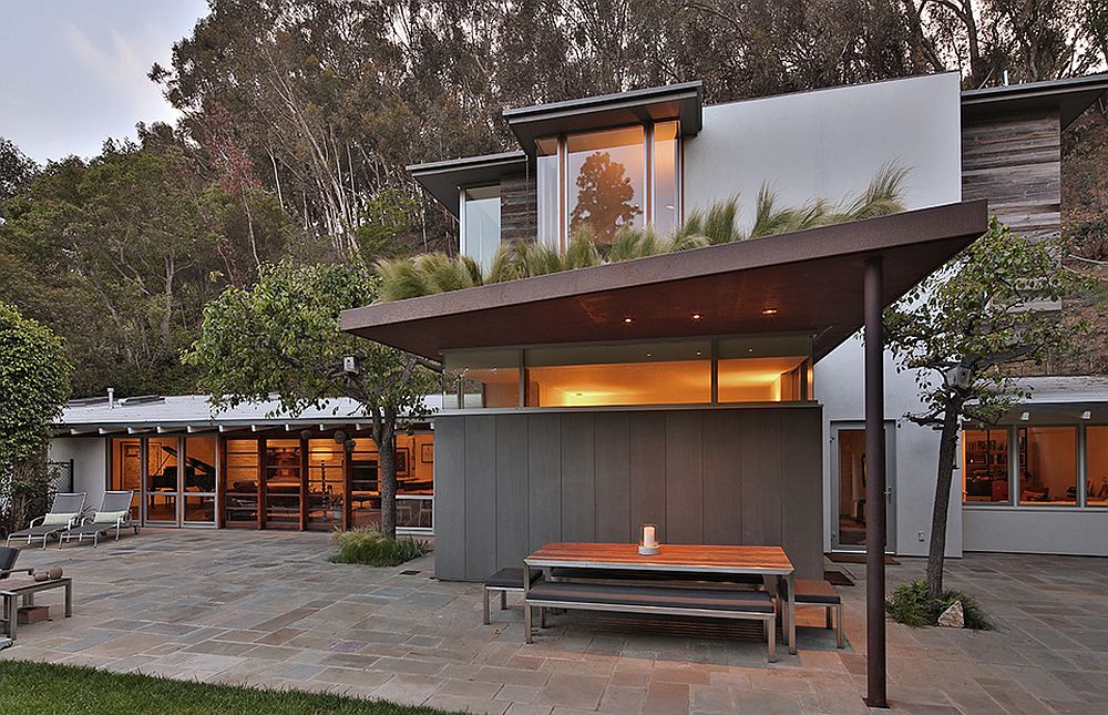 Rustic elements such as the pergola roof provide shade even while adding to the home's aesthetics