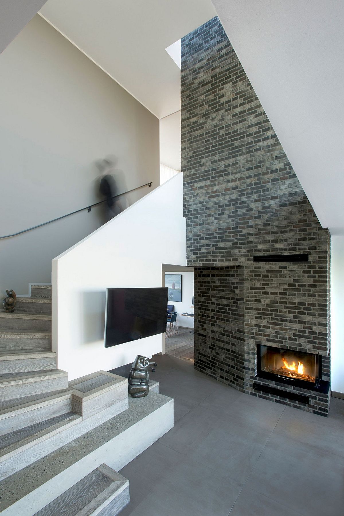 Sculptural staircase and brick fireplace inside the contemporary residence in Denmark