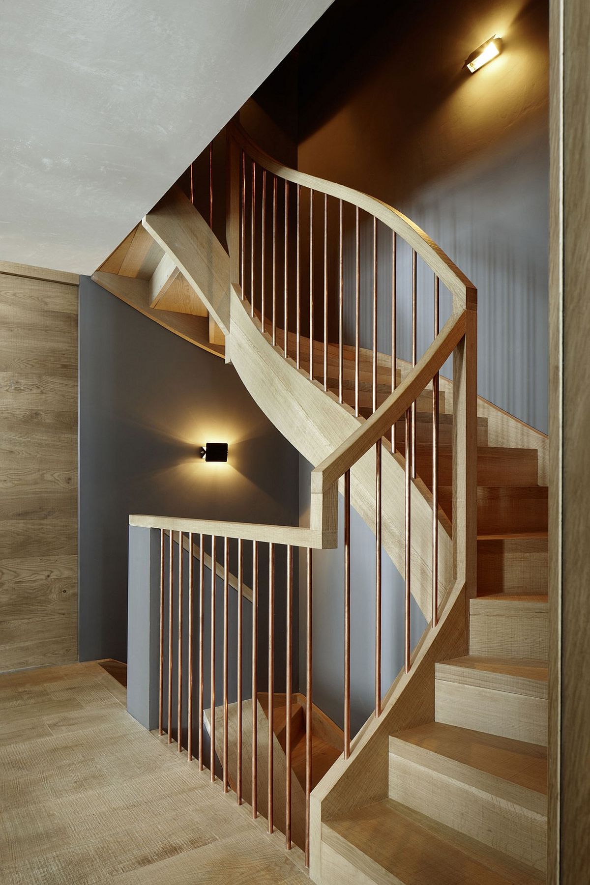 Sculptural staircase in oak with wooden handrail and copper railing