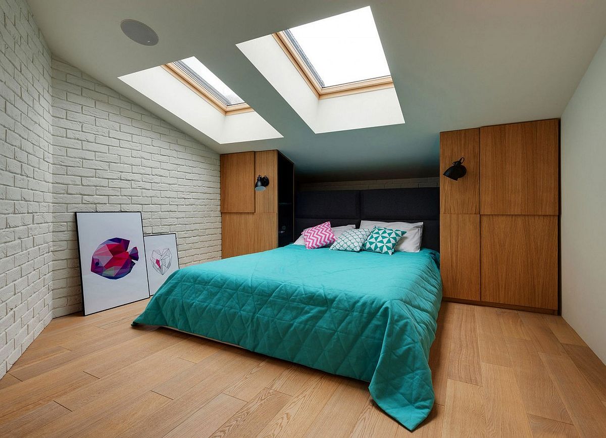 Skylights bring in light into the bedroom on the top level with brick walls