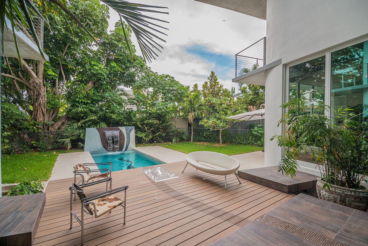 Spacious backyard, wooden deck and pool of the contemporary home