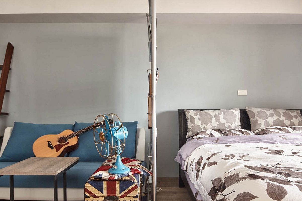 Ultra sleek metal and glass partition between bedroom and living space used as magazine rack