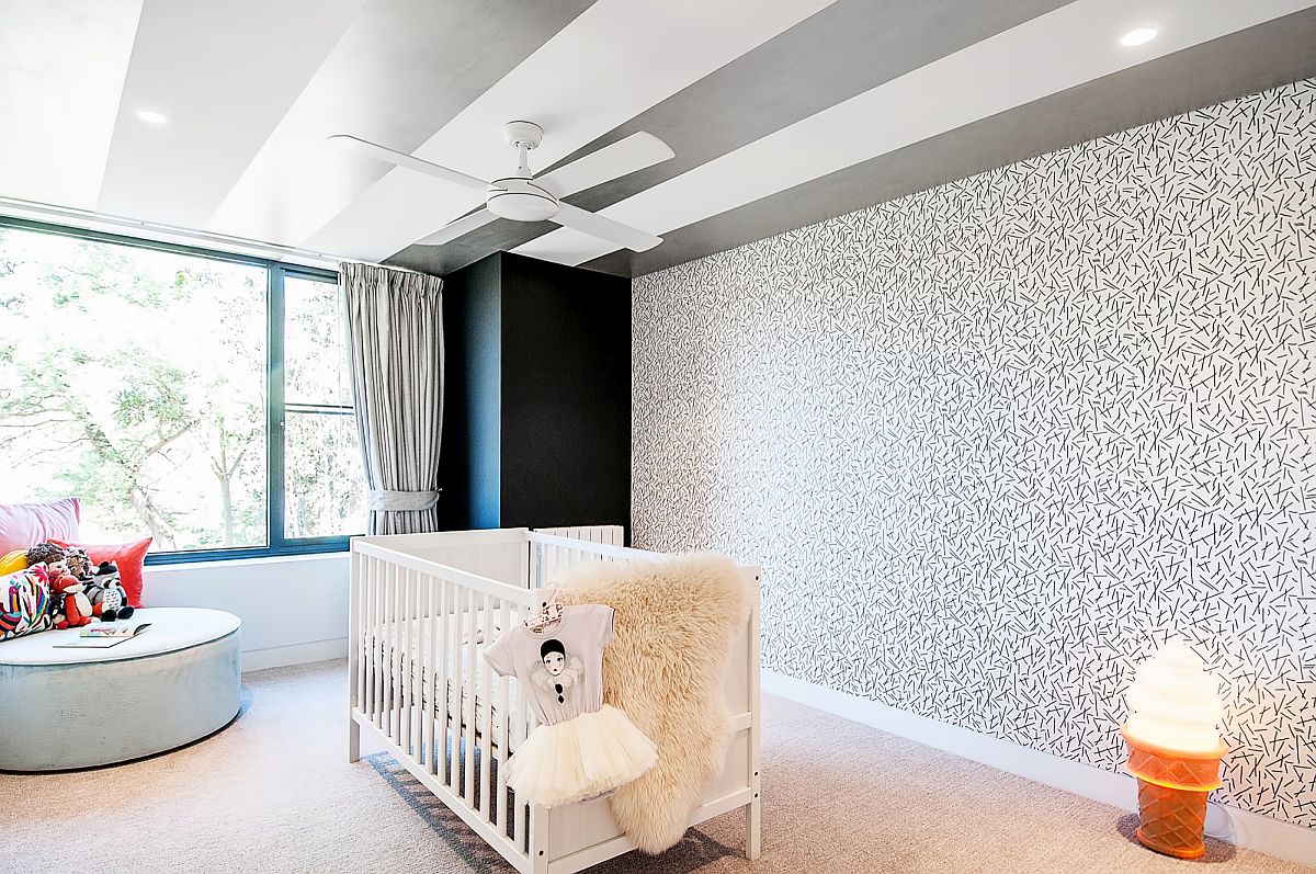 Wallpapered accent wall in the nursery uses less color and more pattern