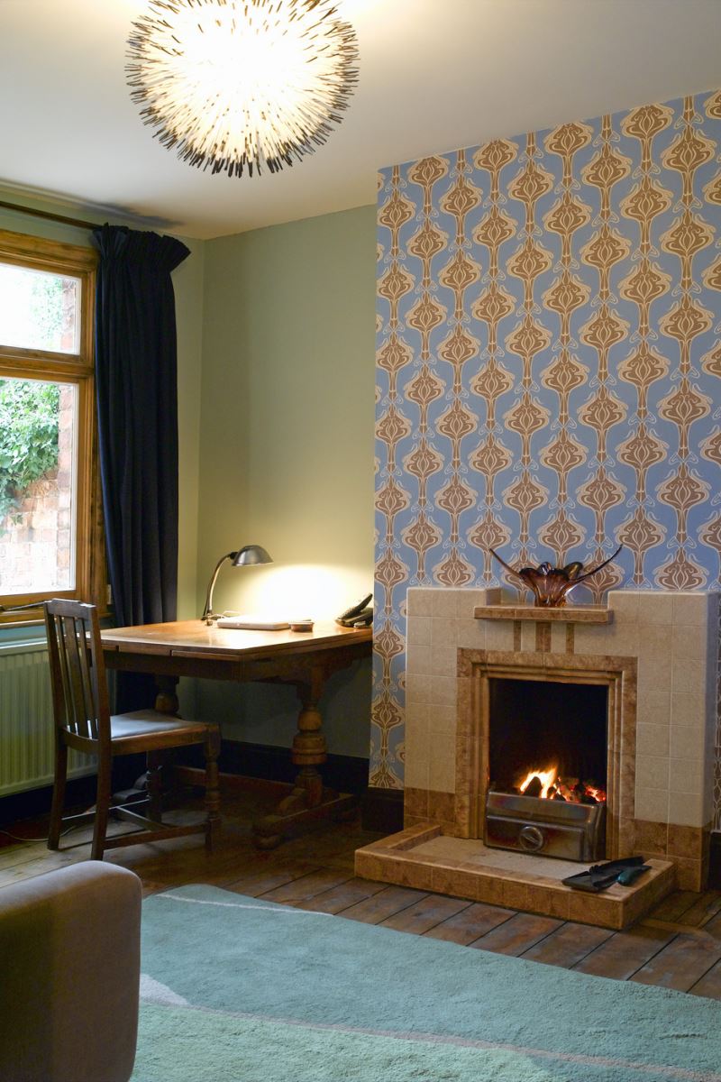 Wallpapered accent wall with a fireplace