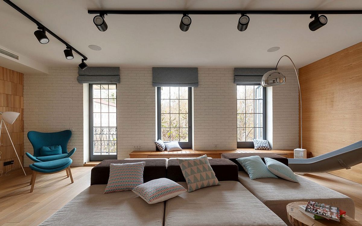 White brick wall adds contrats to the living room visual along with the rich wooden surfaces