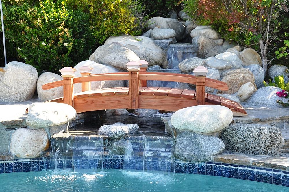 Arched wooden bridge over the water garden is a great way to complete your poolscape