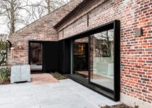 Brick-exterior-of-the-old-farm-house-given-a-new-dark-window-with-sliding-glass-doors-217x155