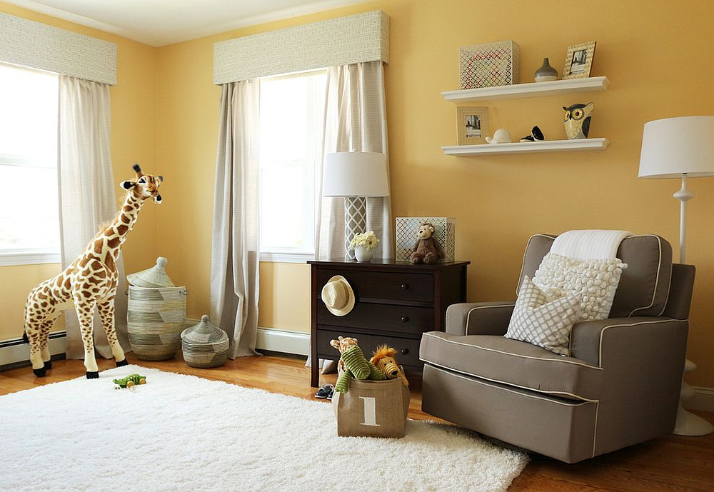 Comfy gray chair provides contrast to the lovely yellow backdrop in the nursery [Design: Victoria Elizabeth Design]