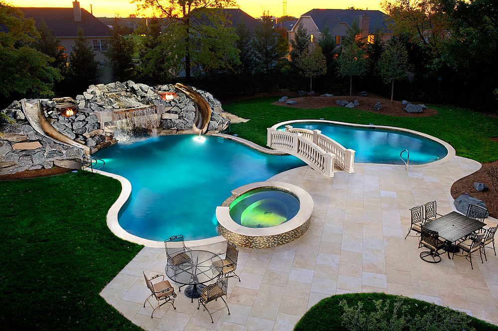 Custom swimming pool and garden with waterfalls, slides and a beautiful bridge [Design: Platinum Poolcare]