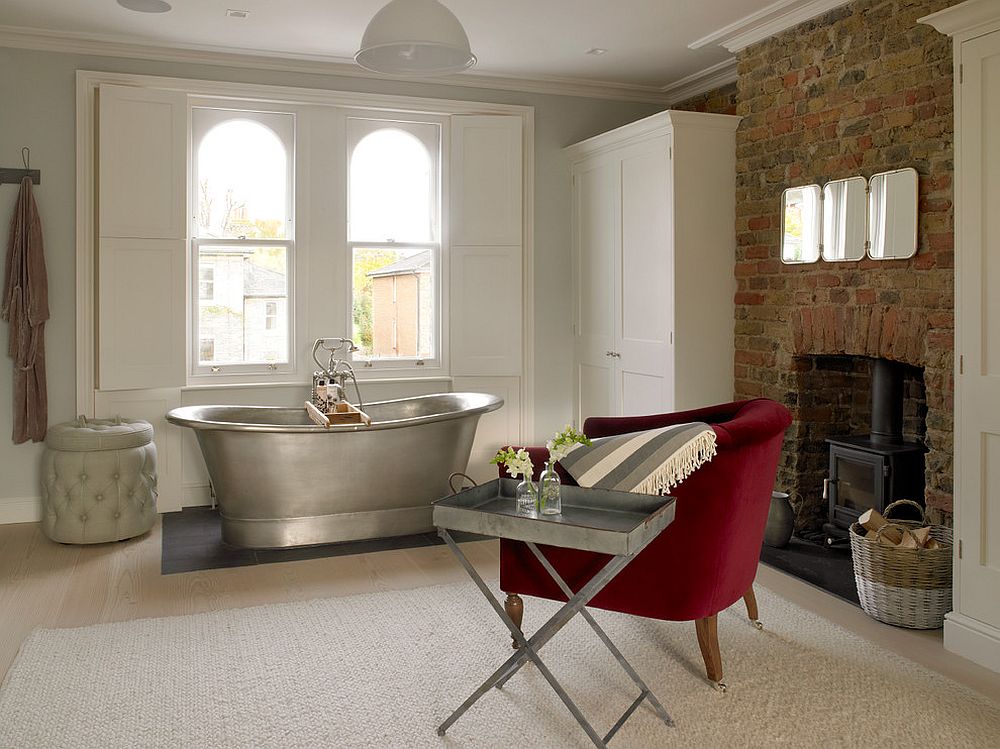 Fireplace and a bright red armchair along with side table transform the transitional bathroom