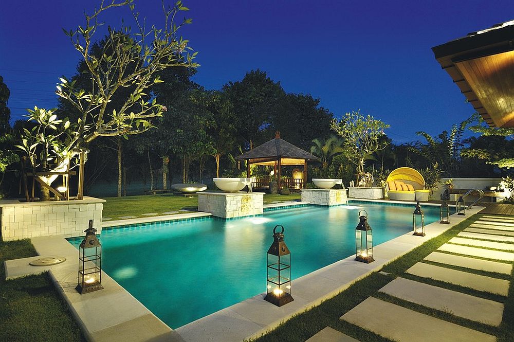 Gorgeous tropical pool with lantern lighting and a gazebo in the distance