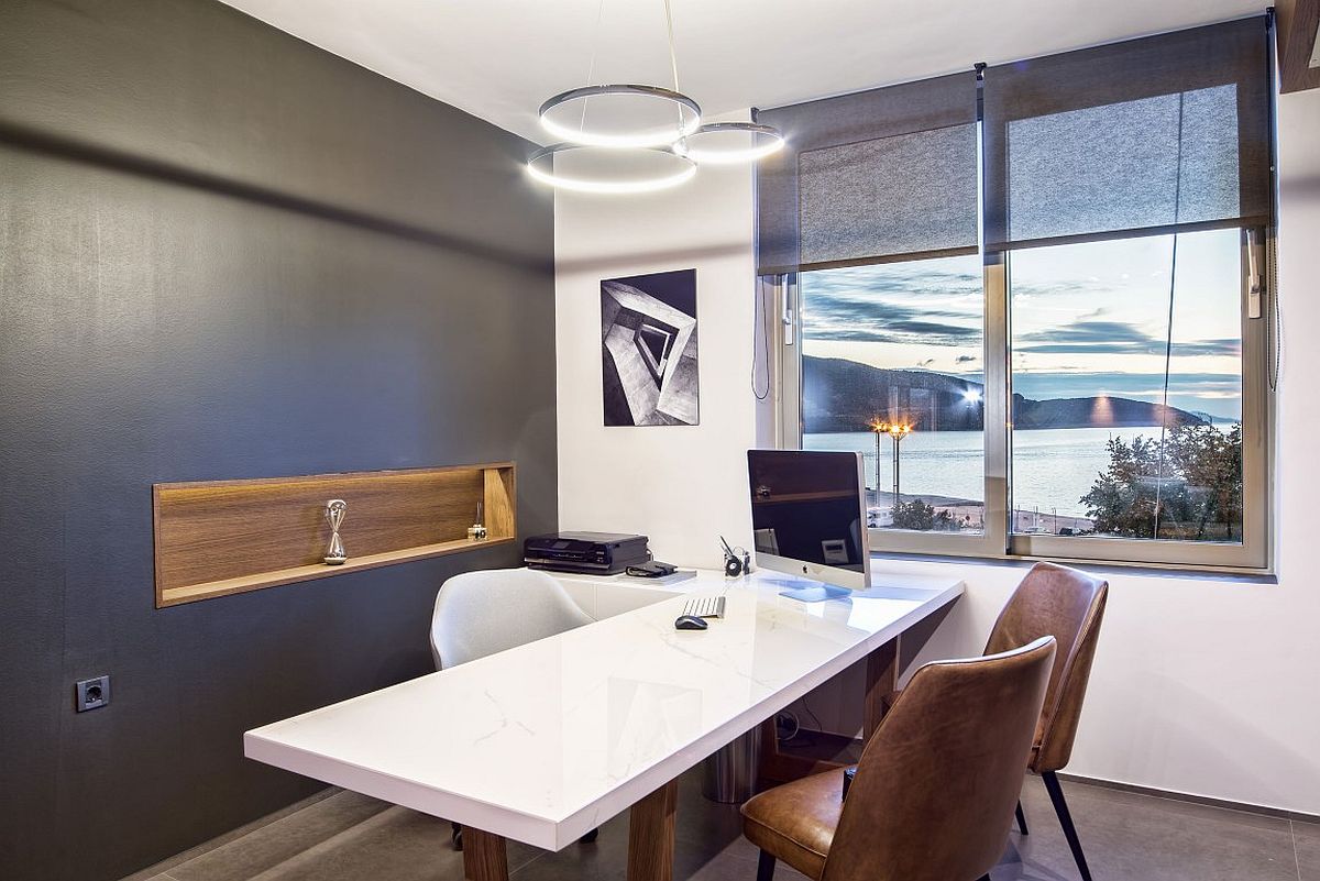 Gray accent wall and white backdrop highlight the sea view outside the window