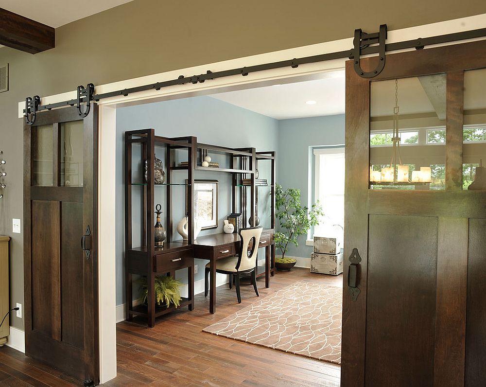 Industrial, barn-style doors conceal a spacious and traditional home office