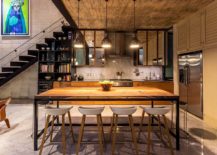 Metallic-pendant-lights-for-the-dining-space-with-a-bookshelf-and-kitchen-in-the-backdrop-217x155
