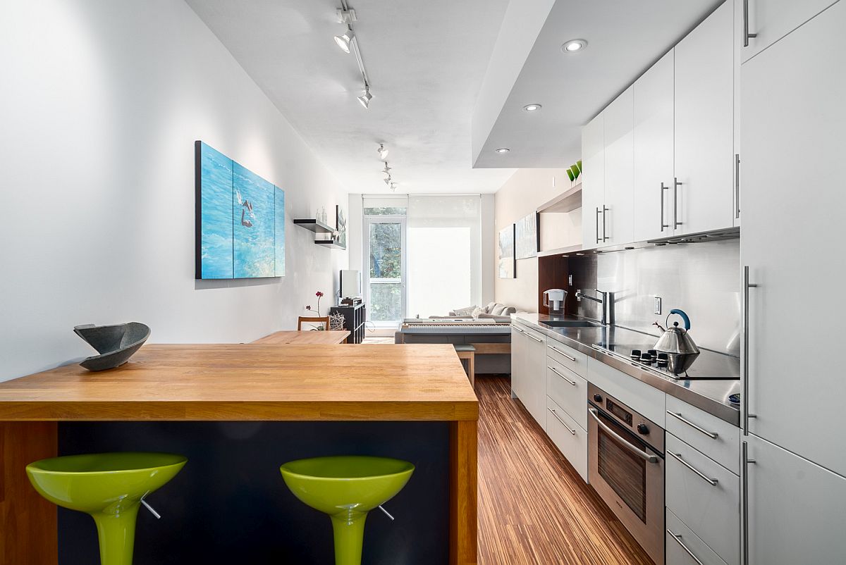 Narrow kitchen with lovely little breakfast zone and colorful bar stools