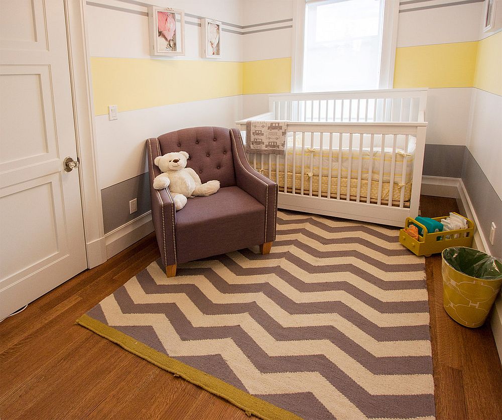 Small nursery with chevron pattern rug and striped wall 