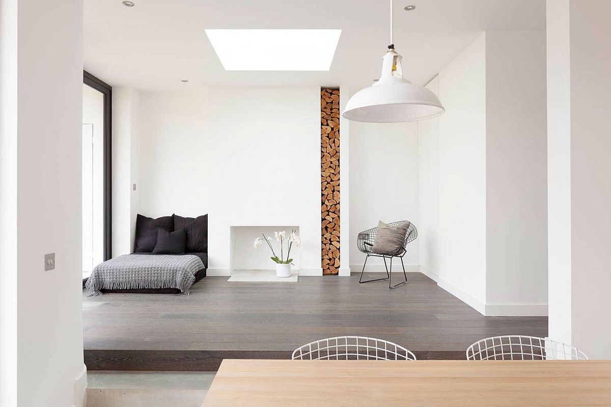 Stacked firewood is used as a decorative element inside the modern minimal London home