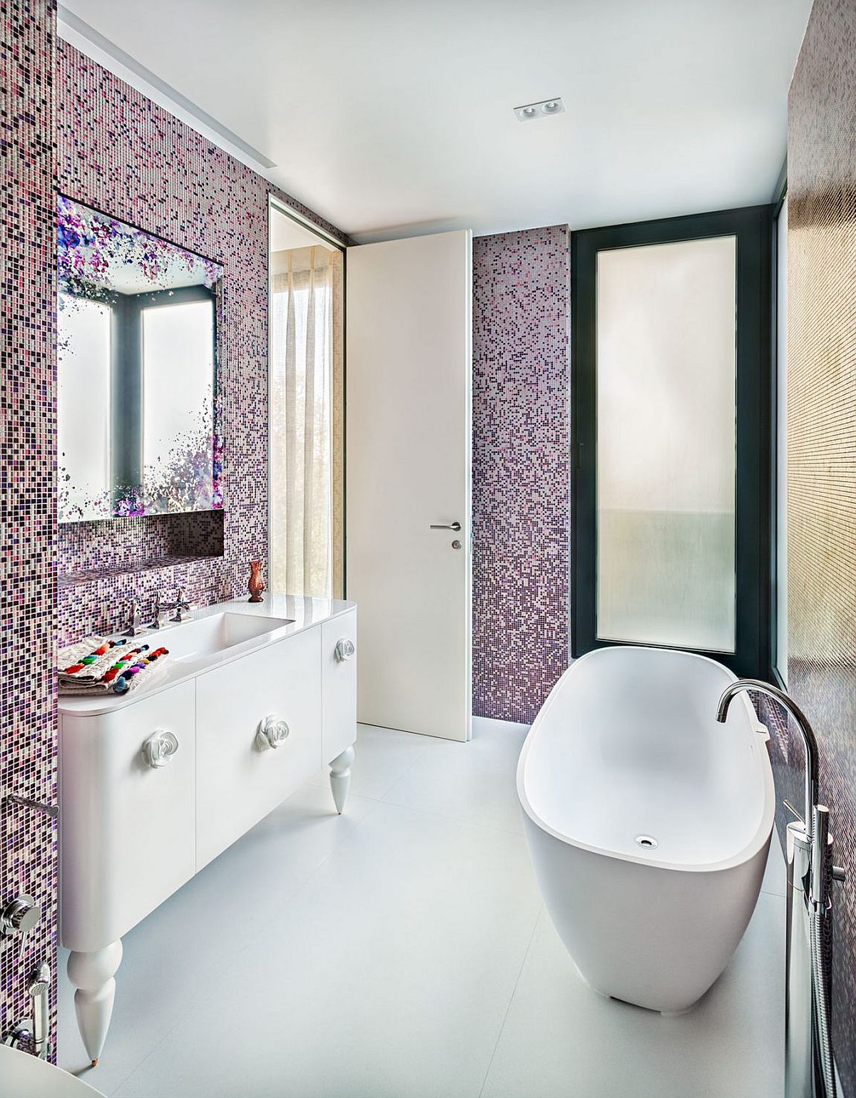 Stunning contemporary bathroom with standalone bathtub and tiles that usher in shades of violet