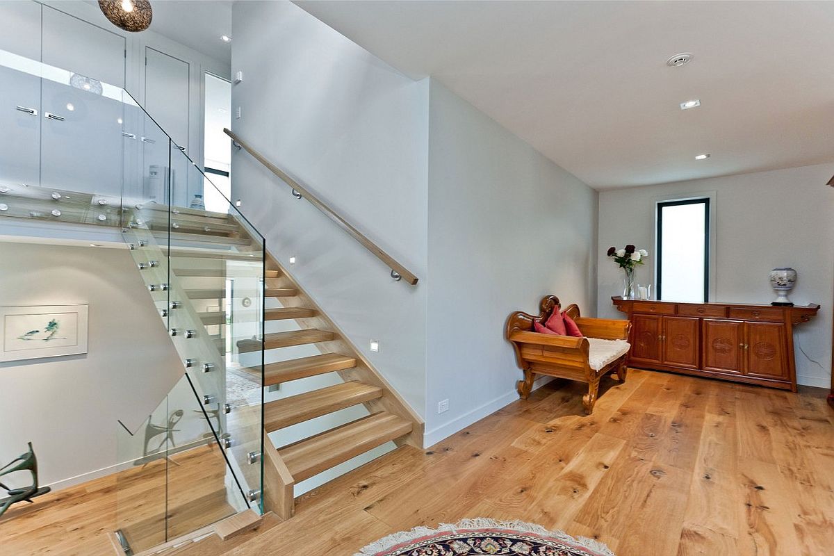 Traditional decor pieces sit next to contemporary staircase at this Auckland home