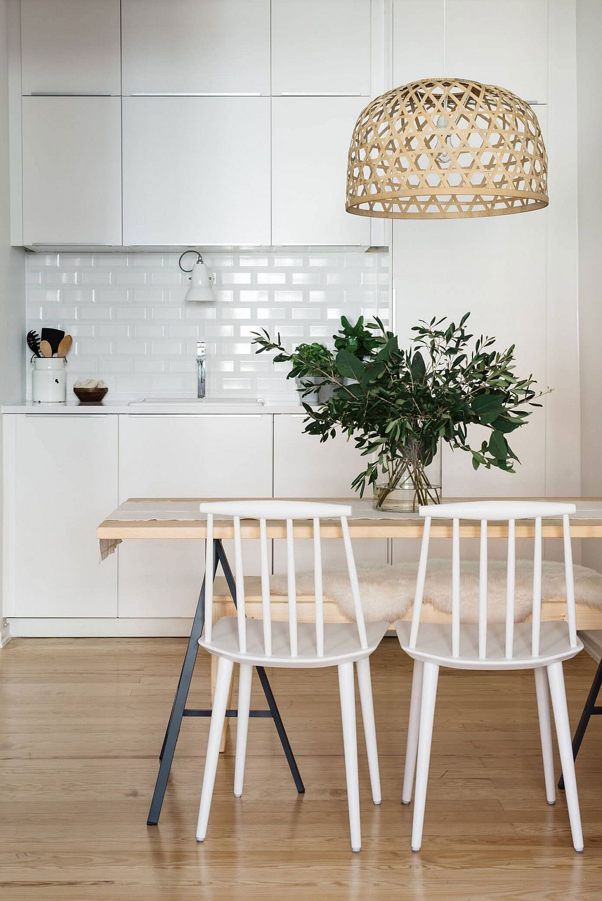 Unique lighting fixture, wooden table and sleek chairs give the kitchen a modern Scandinavian feel