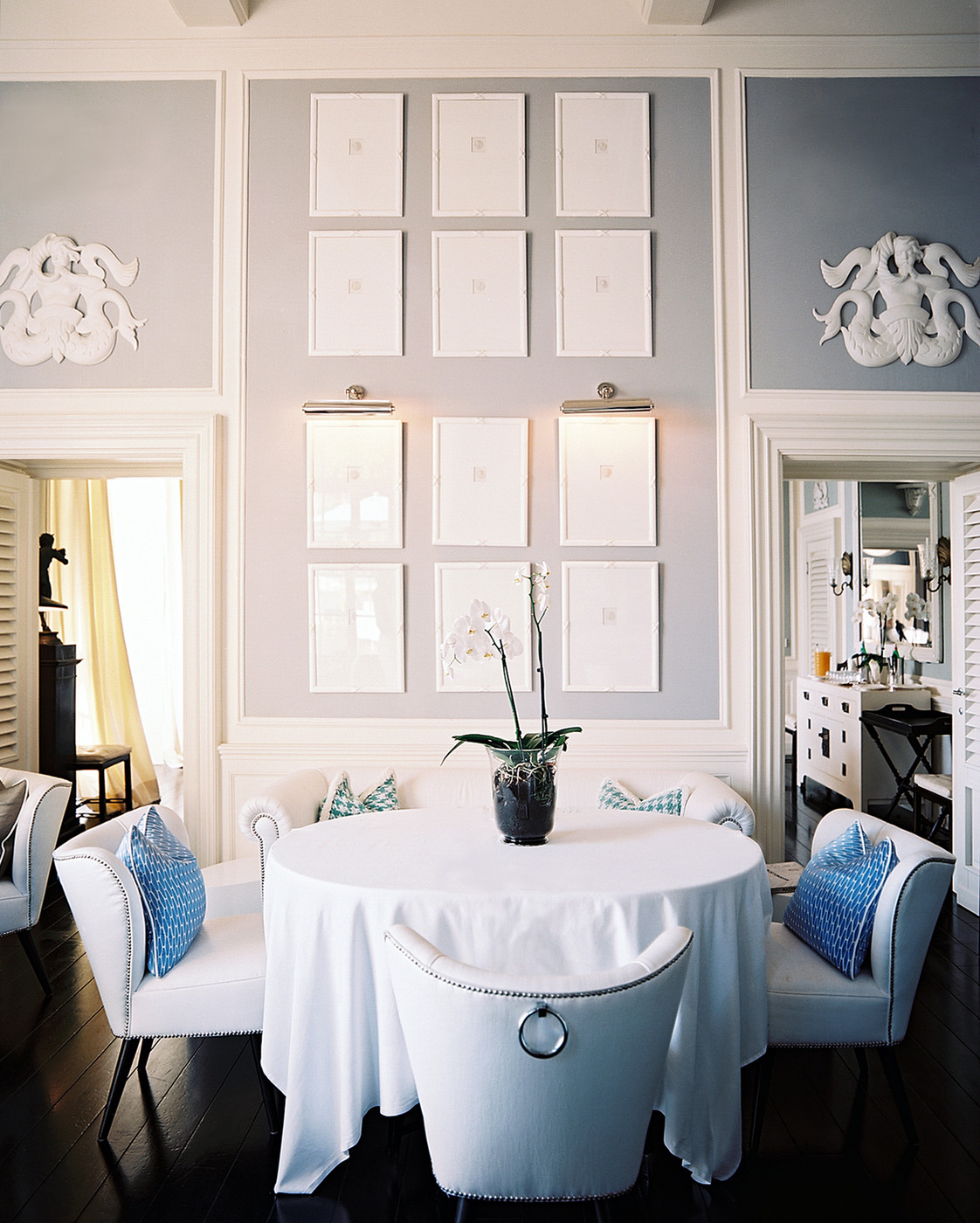 White seating surrounds a white round tablecloth