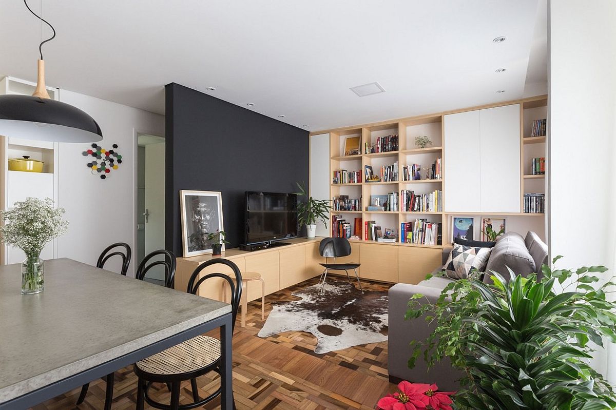 Wooden cabinets, open shelves and a black wall fashion a fabulous living area