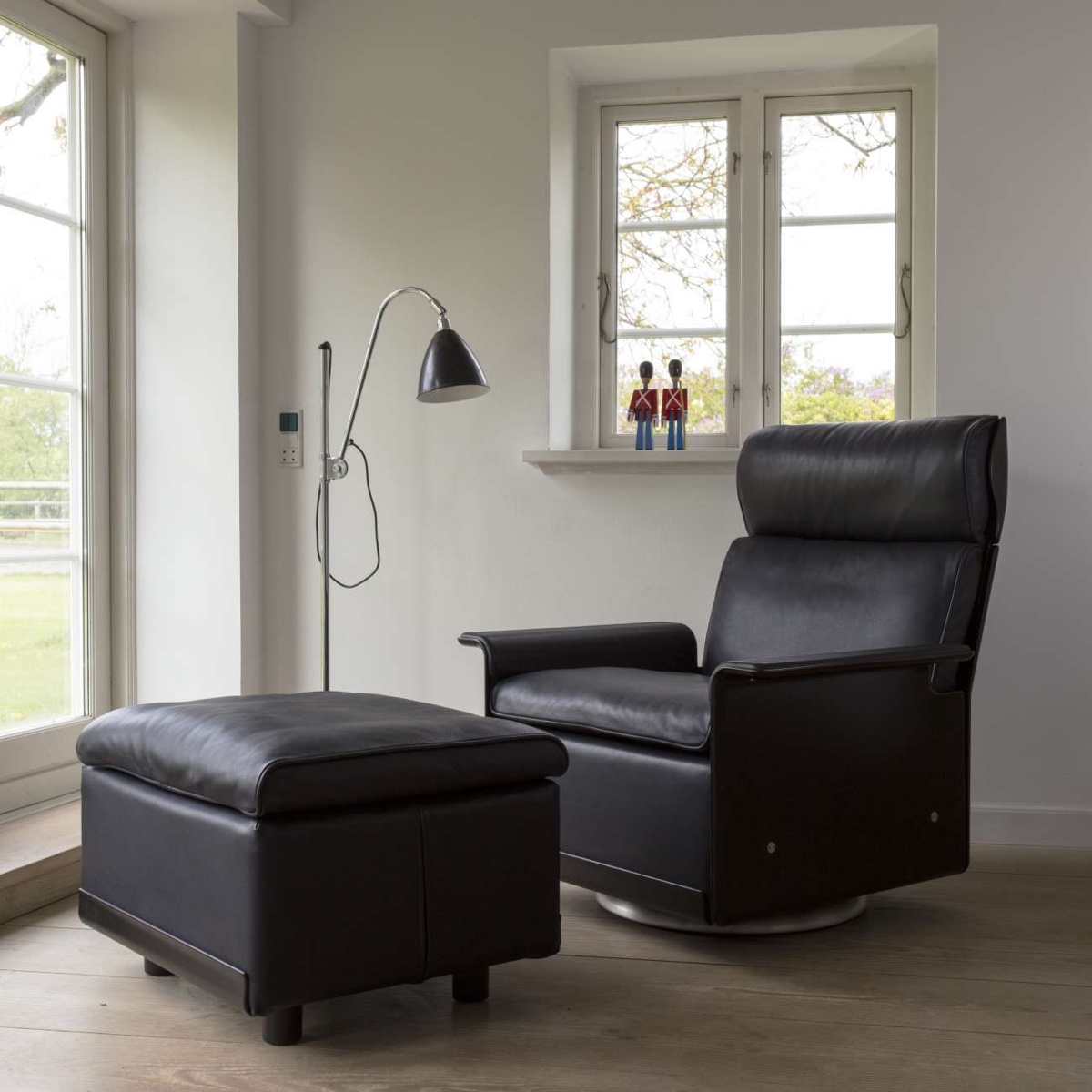 A subtle combination of midnight-blue leather and black shell make up this high-back chair and footstool from the 620 Chair Programme. Image © Vitsœ.