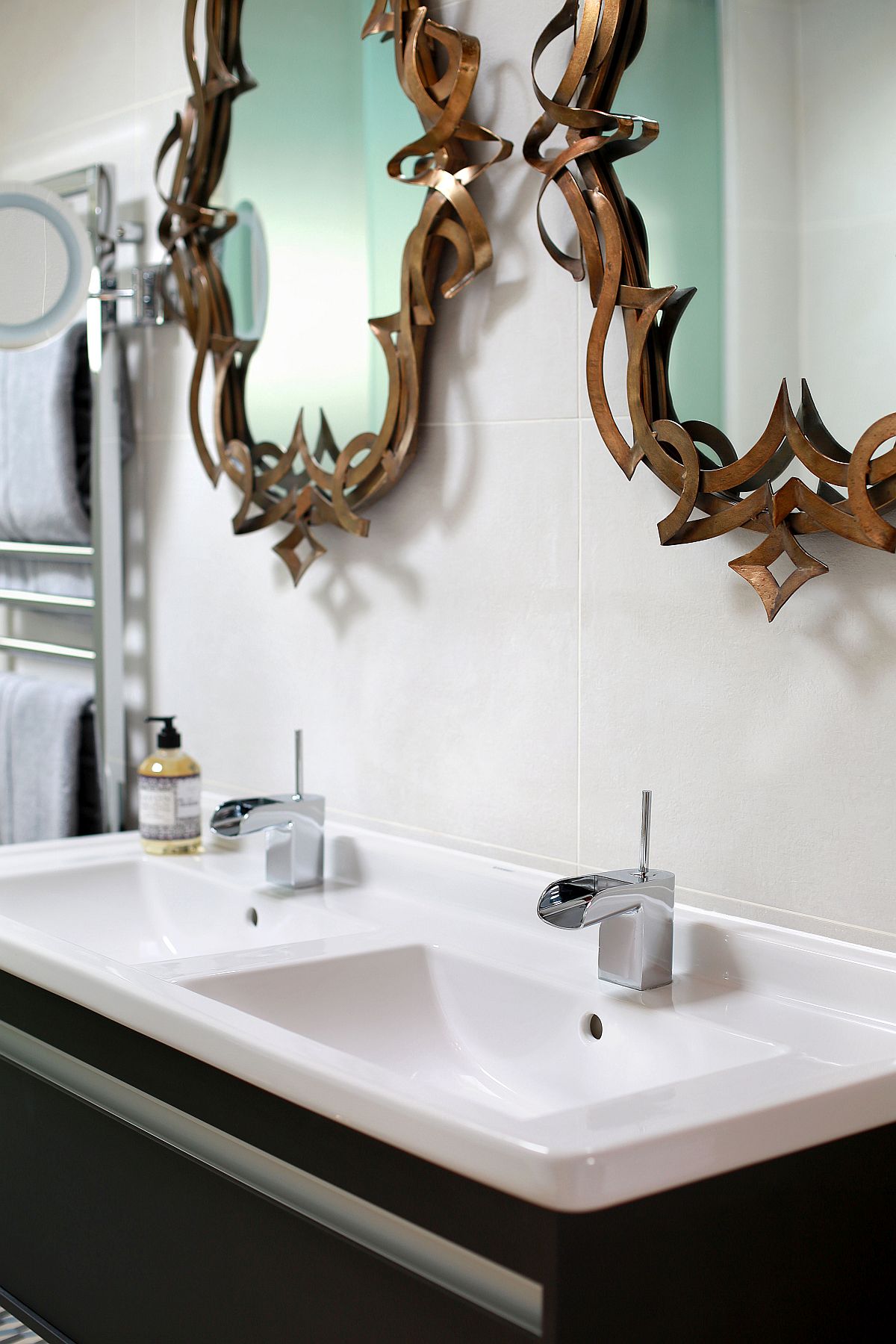 A closer look at the floating bathroom vanity and bronze mirrors