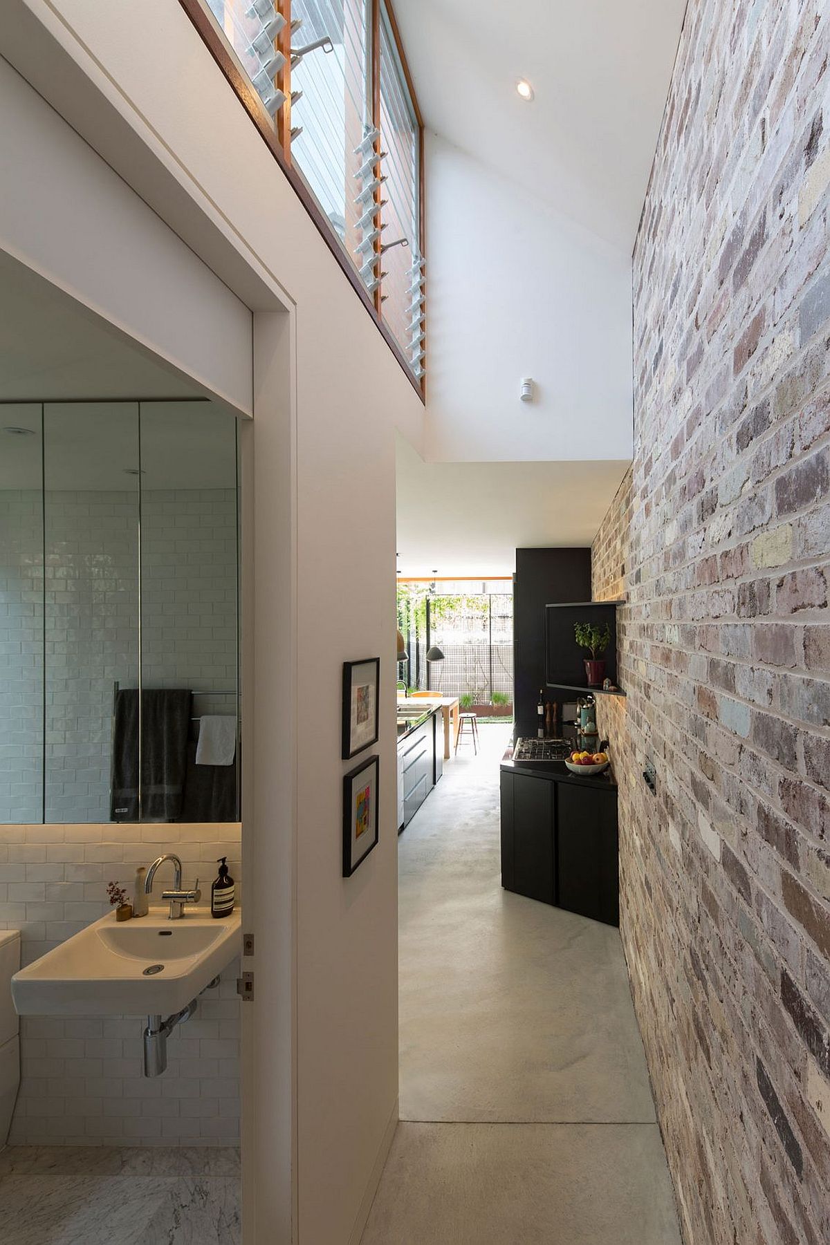 Artificial lighting coupled with natural light highlights the beauty of the exposed brick wall