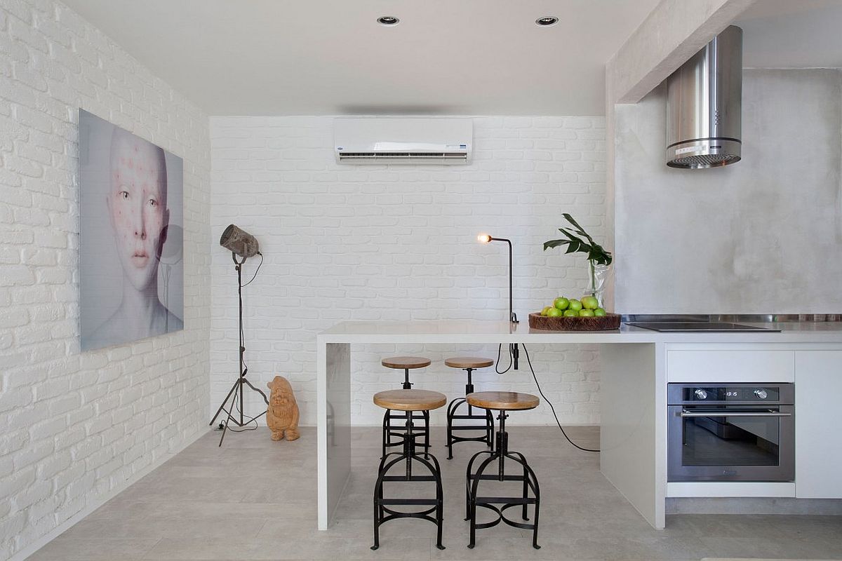 Bar stools and tripod floor lamp in the kitchen give it a industrial modern style