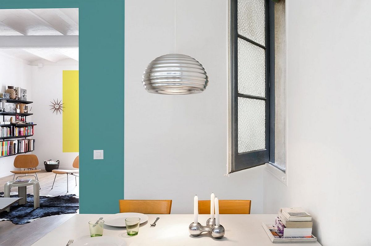 Bright, metallic pendant and window enliven the small dining space