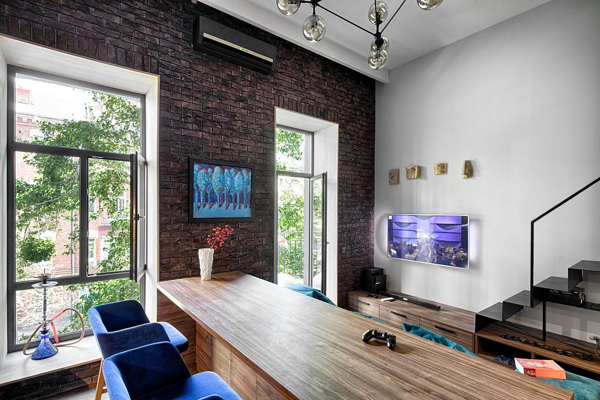 Custom wooden kitchen island and cabinetry along with bold blue bar chairs