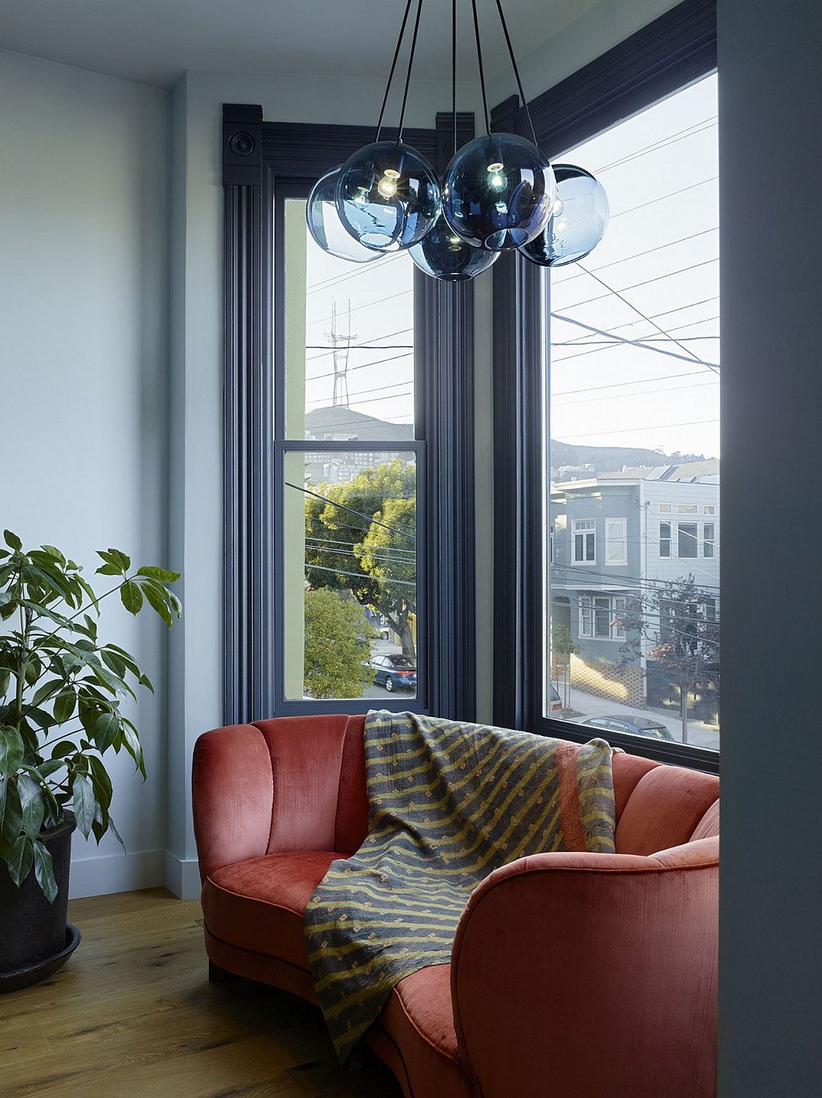 Globe chandelier and bright pink couch give the modern interior a VIctorian touch