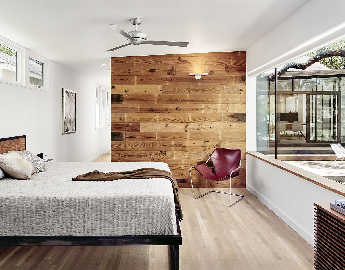 Master bedroom with accent wooden wall opens up towards the outdoors