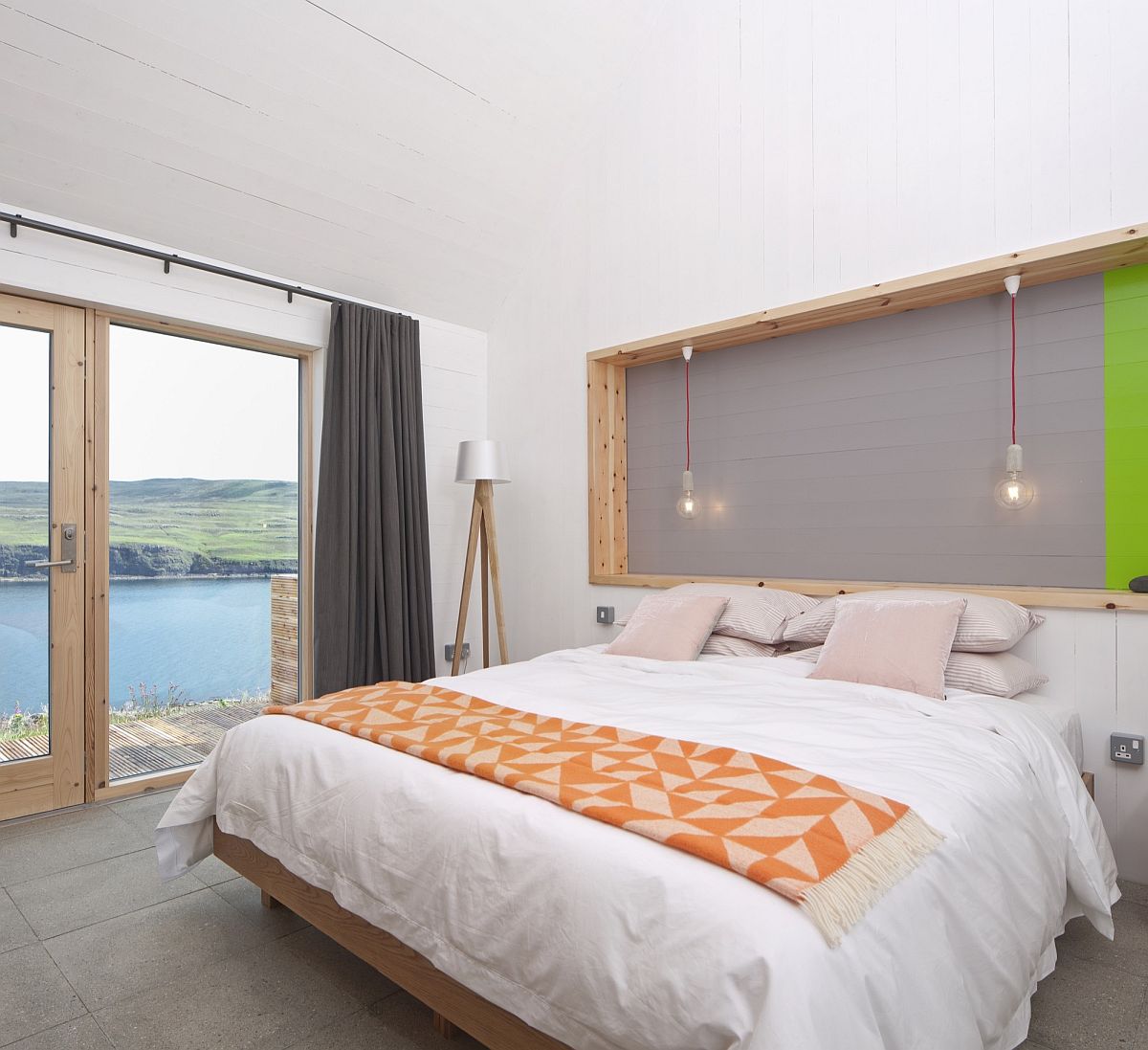 Modern bedroom with nature views and pops of orange and green